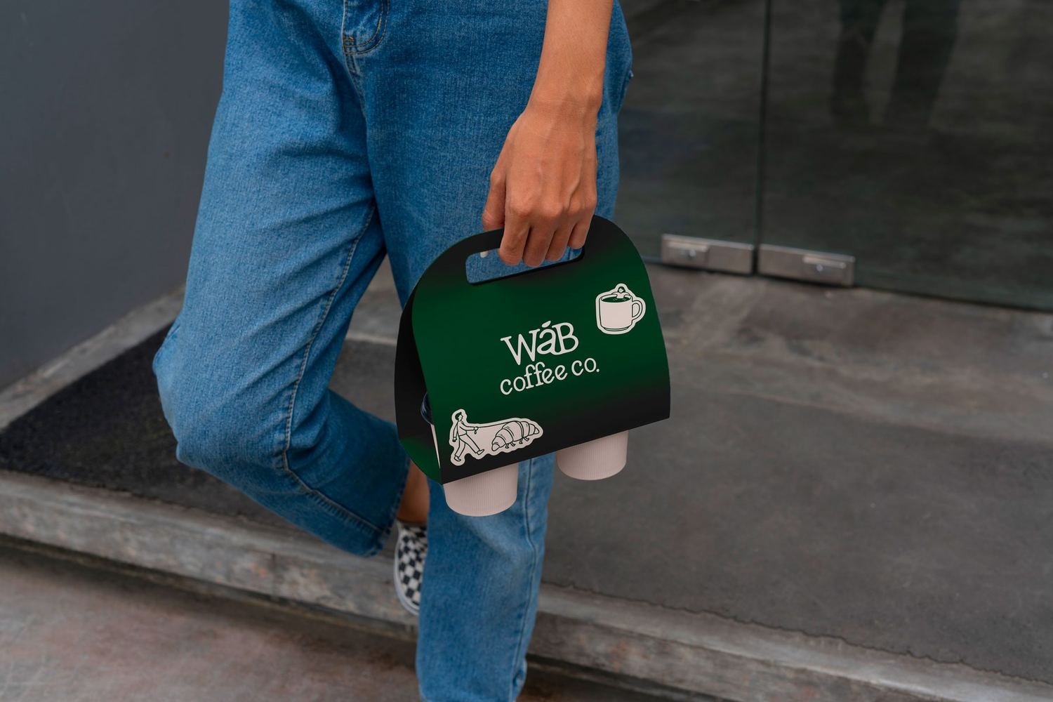 Green WÁB takeaway carrier photographed beside denim